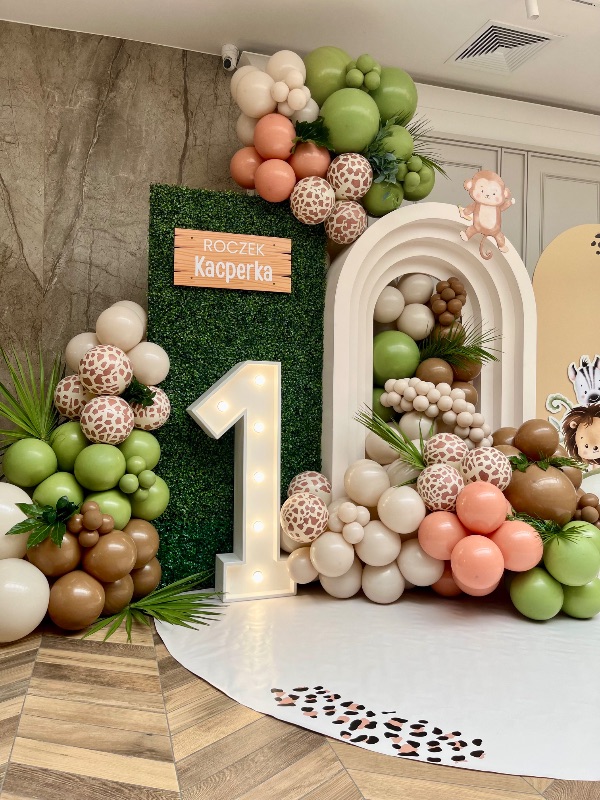 Roczek w stylu safari - zielona ścianka, balony w kolorach ziemi i podświetlana cyfra 1 w Hotelu Toscania