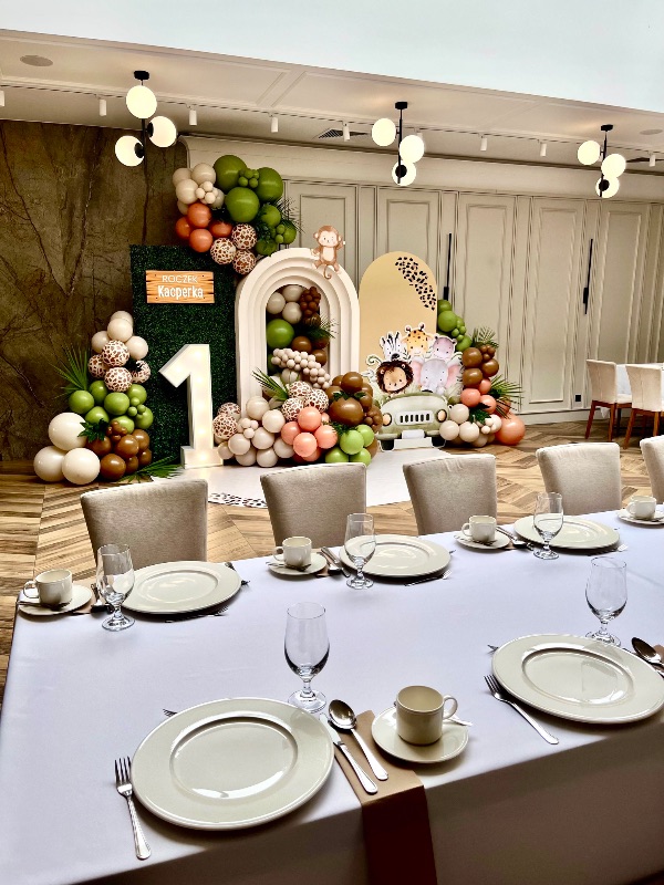 Roczek w stylu safari - ścianka z balonami i zwierzątkami oraz nakryty stół w Hotelu Toscania