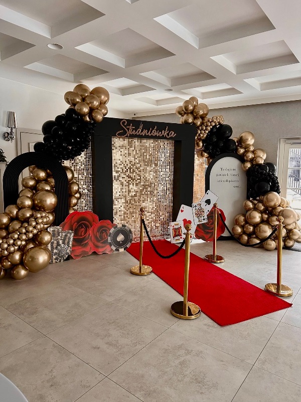 Dekoracja studniówki w stylu casino - czerwony dywan, złote balony i cekinowa ścianka