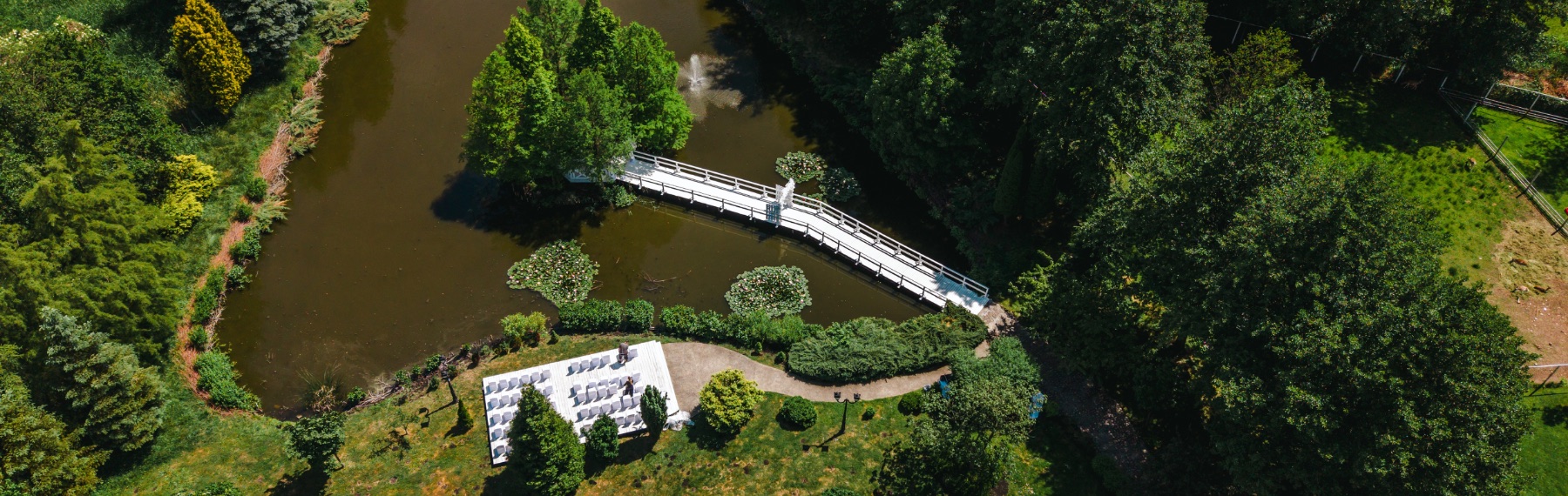 Ślub cywilny w plenerze - kwiatowa brama i altana na mostku nad stawem w ogrodzie Hotelu Toscania